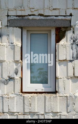 Fenêtre installée de manière non professionnelle dans la façade d'une maison avec des défauts de construction Banque D'Images