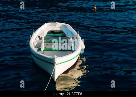 Pêche bateau blanc en bois avec des oars sur l'eau bleue de la baie de Kotor au Monténégro. Banque D'Images