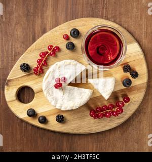 Une photo en hauteur du fromage Camembert avec un verre de vin rouge et de fruits Banque D'Images