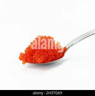 Caviar de saumon kéta rouge à grain frais dans une cuillère métallique, fond blanc Banque D'Images