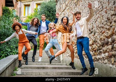 Groupe multiethnique de jeunes fous sautant dans les escaliers de la rue de la ville et s'amusant - concept urbain Banque D'Images