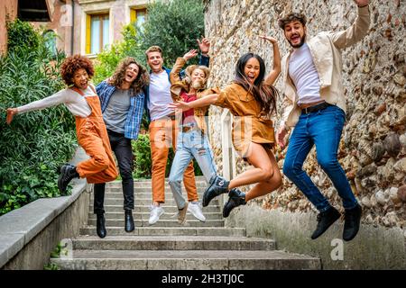 Groupe multiethnique de jeunes fous sautant dans les escaliers de la rue de la ville et s'amusant - concept urbain Banque D'Images