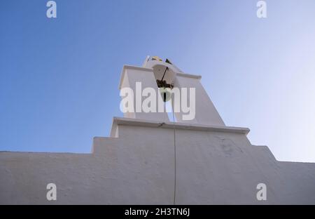 Grèce, Cyclades.Île de Folegandros, ancienne église beffroi à la ville de Chora.Chapelle traditionnelle des Cyclades, murs blanchis à la chaux, fond ciel bleu clair. Banque D'Images