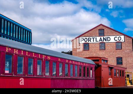 Portland, Maine - Etats-Unis - 10-28-2021: Un train rouge se trouve devant l'ancien bâtiment Portland Co à Portland Maine. Banque D'Images