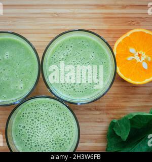 Bonjour : smoothies verts frais et fruits sur fond de bois, petit déjeuner sain Banque D'Images