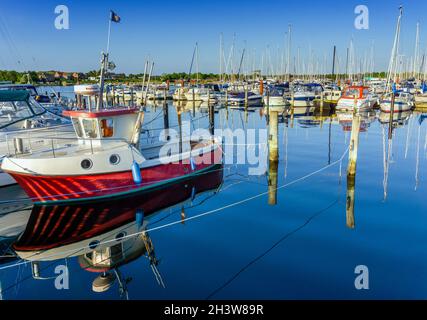 Bateaux à moteur et voiliers colorés dans le port de plaisance et le port de plaisance de Middelfart dans le sud du Danemark dans la lumière chaude du soir Banque D'Images