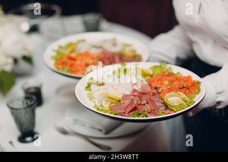 Diverses coupes froides sur une plaque avec des fleurs blanches sur la table Banque D'Images