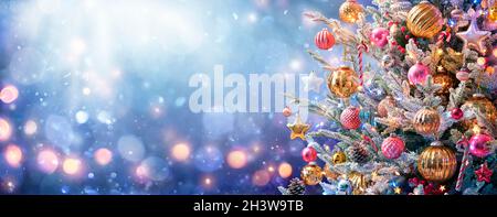 Arbre de Noël - décorations et neige sur fond bleu avec lumières brillantes Banque D'Images