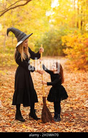 Mère et fille qui balaie le chemin le jour de l'Halloween Banque D'Images