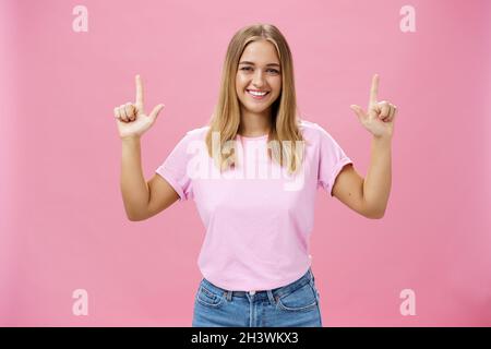 Photo en intérieur d'une jolie fille à l'aspect sympathique avec une peau bronzée dans un t-shirt décontracté et un Jean qui soulève les mains vers le haut Banque D'Images