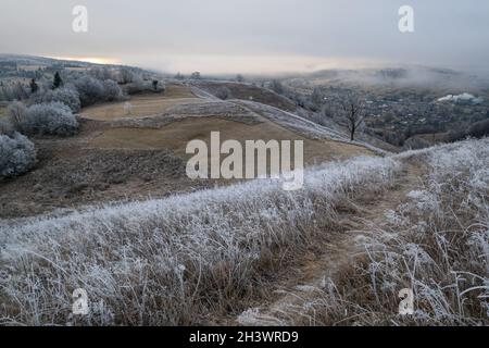 L'hiver approche.Scène pittoresque avant le lever du soleil au-dessus de la fin de l'automne campagne de montagne avec du givre sur les herbes, les arbres, les pentes.PE Banque D'Images