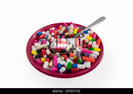 Bol de pilules et de capsules avec fond blanc. Banque D'Images