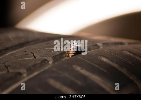 Roue de voiture crevée.Crevaison de la roue de voiture, vis en acier dans le pneu, vue rapprochée Banque D'Images