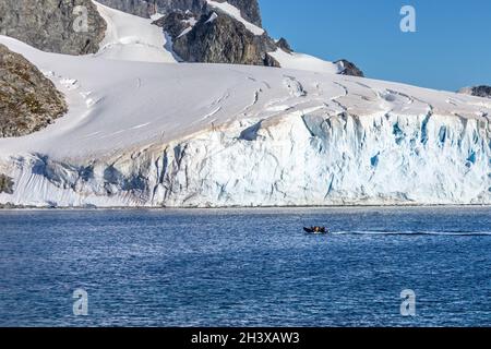 Bateau plein de touristes passant par l'immense glacier dans la baie près de l'île de Cuverville, péninsule antarctique Banque D'Images