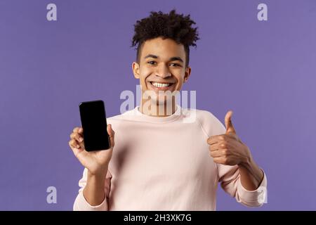 Portrait en gros plan de jeune homme joyeux et satisfait client recommander l'achat d'abonnement à un jeu ou une application, l'apprentissage leanguage vi Banque D'Images