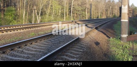 Panorama de deux voies de chemin de fer à un tournant dans la forêt. La route sur laquelle les trains se déplacent, Voyage par le train. Banque D'Images