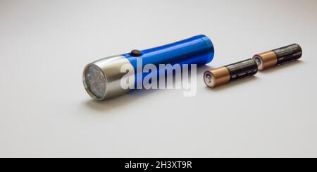 Lampe de poche bleue avec piles isolées sur fond blanc Banque D'Images