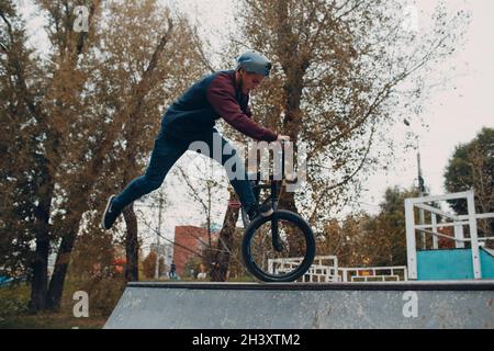 Cycliste professionnel jeune sportif avec vélo bmx au Skate Park. Banque D'Images