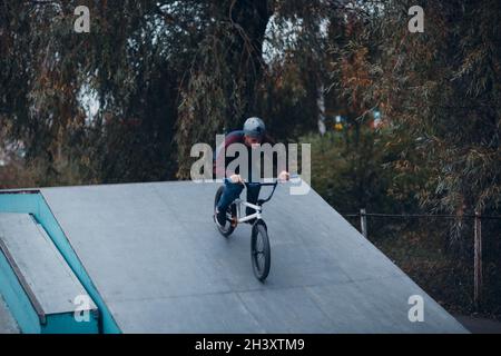 Cycliste professionnel jeune sportif avec vélo bmx au Skate Park. Banque D'Images