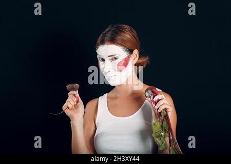 Jeune femme appliquant le maquillage, peint le visage avec la betterave et le maquillage.Comment ne pas faire de concept de maquillage Banque D'Images