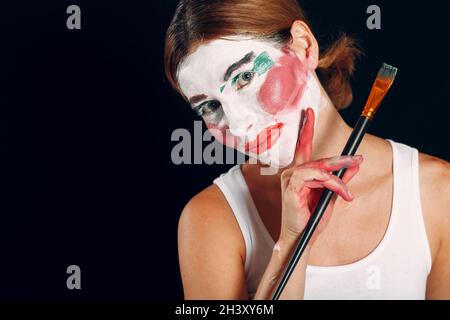 Jeune femme appliquant le maquillage, peint le visage avec pinceau et maquillage. Comment ne pas faire de concept de maquillage Banque D'Images