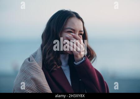 Jeune belle femme riant la bouche près à la main. Banque D'Images