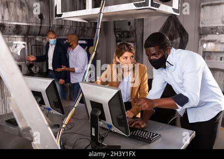Amis avec masque de visage jouant dans la salle de quête Banque D'Images