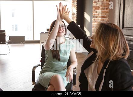 Deux femmes d'affaires heureuses et réussies se donnant cinq hauts l'une à l'autre au bureau Banque D'Images