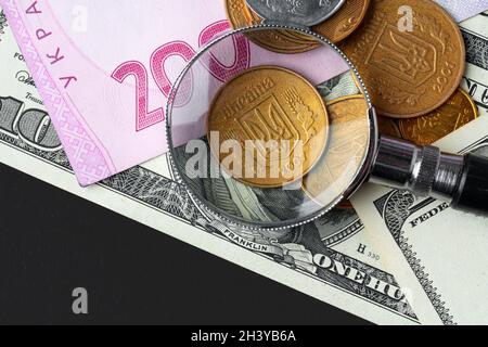 Loupe sur les billets de banque en dollars ukrainiens hryvnia et US.Concept de taux de change Banque D'Images