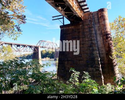 Ponts de chemin de fer sur pierre et briques piers au-dessus de la rivière au soleil avec ciel bleu Banque D'Images