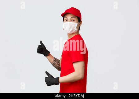 Wow livraison très rapide.Excitée homme de livraison asiatique en casquette rouge et t-shirt, porter un masque médical de protection, des gants, tourner à la caméra Banque D'Images
