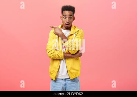 Portrait d'un homme afro-américain de bonne qualité impressionné avec une barbe et une coupe de cheveux en rafles en levant les sourcils ouverture de la bouche pointant vers le haut Banque D'Images