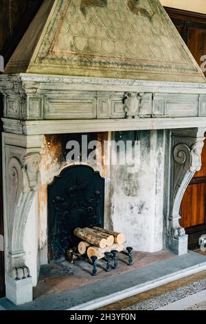 Ancienne cheminée dans la maison. Une ancienne cheminée dans la maison avec des colonnes et des bas-reliefs. Banque D'Images