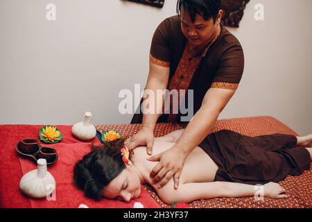 Homme thaïlandais effectuant un massage thaïlandais classique à la jeune femme au spa de beauté Banque D'Images