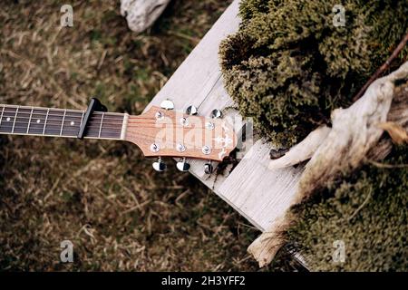 Guitare fretboard et tête de lit sur l'herbe verte dans la nature. Banque D'Images