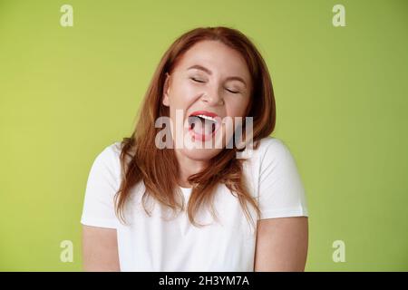 Les week-ends paresseux finissent par dormir.Gai redhead moyenne-âge 50s femme bâillant satisfait les yeux proches se sentent endormis se réveiller tôt Banque D'Images