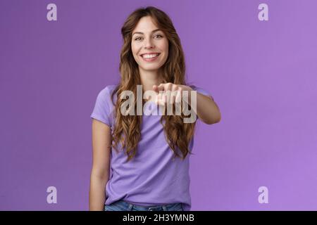 Fille gaie vous pointant.Sympathique sympathique sympathique sympathique souriant courbé-cheveux femelle décidant qui choisit l'indicateur de doigt appareil photo gri Banque D'Images