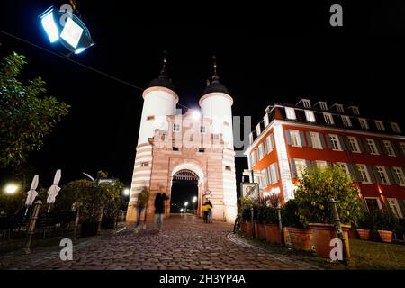 Heidelberg, Allemagne.28 octobre 2021.Les gens marchent à travers la porte du pont à l'Old Bridge.La ville veut interdire aux kiosques contenant de l'alcool dans l'assortiment de vendre de l'alcool à haute épreuve la nuit afin d'éviter de boire des bites qui sortent de la main.(À dpa beuge boire dans la vieille ville - Heidelberg introduit l'interdiction de la vente d'alcool) Credit: Uwe Anspach/dpa/Alamy Live News Banque D'Images