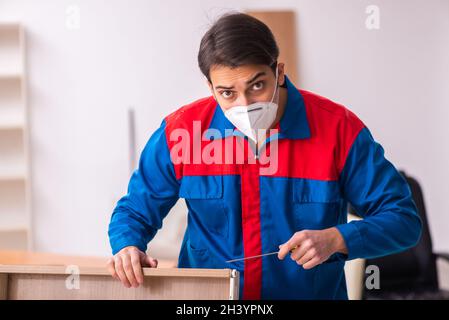 Jeune menuisier de sexe masculin travaillant au bureau pendant une pandémie Banque D'Images