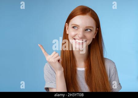 Wow intéressant.Curieux attrayant sourire jeune 20s étudiant de sexe féminin trouver une bonne offre de prix produit look pointant vers le haut gauche maïs Banque D'Images