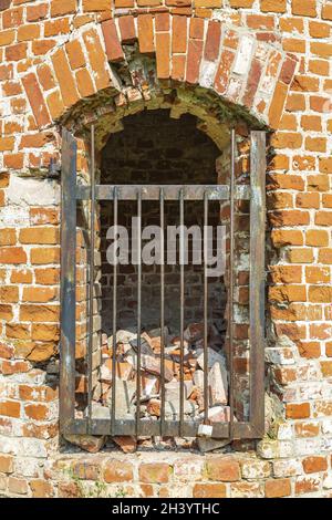Niche dans une ancienne tour en brique avec grille métallique Banque D'Images