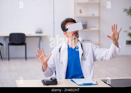 Jeune médecin de sexe masculin portant des lunettes virtuelles dans la clinique Banque D'Images