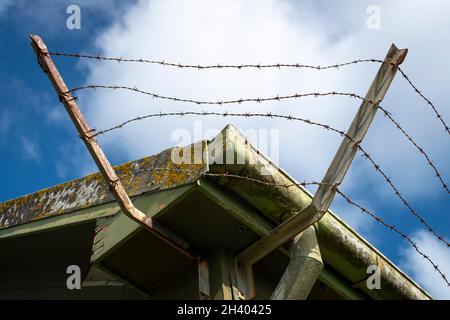 Fil barbelé autour du toit de l'ancien bâtiment, Titahi Bay, Porirua, Wellington, Île du Nord,Nouvelle-Zélande Banque D'Images