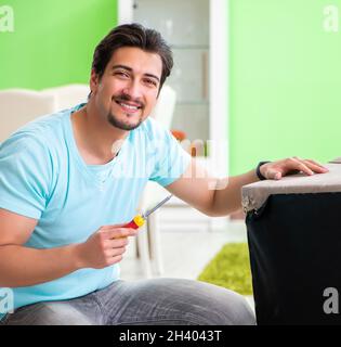 L'homme la réparation de meubles à la maison Banque D'Images