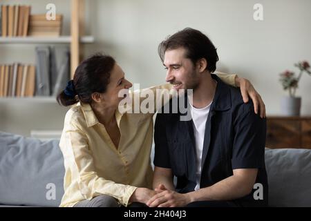 Heureuse femme à la retraite d'âge moyen parlant à son fils adulte. Banque D'Images