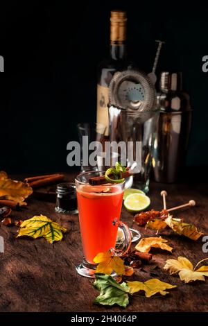 Rhum au beurre chaud, cocktail chaud d'hiver avec jus de pomme, rhum foncé, miel, cannelle en verre sur fond de bois Banque D'Images