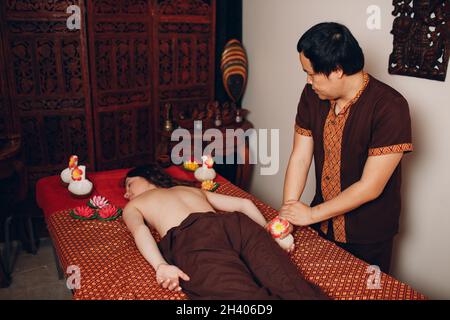 Homme thaïlandais effectuant un massage thaïlandais classique à la jeune femme au spa de beauté Banque D'Images