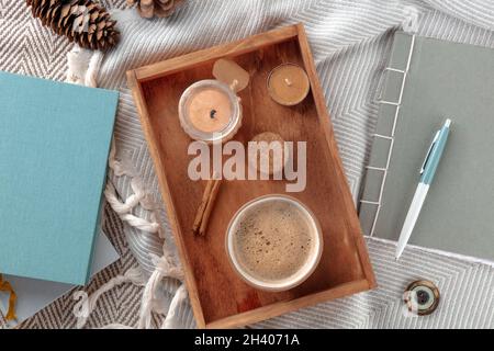 Hygge.Agréable matin d'hiver.Une tasse de café avec bougies parfumées et une couverture Banque D'Images