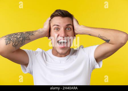 Concept de mode de vie, d'été et d'émotions des gens. Portrait en gros plan de très heureux se réjouir jeune homme regardant surpris, ne peut pas Banque D'Images