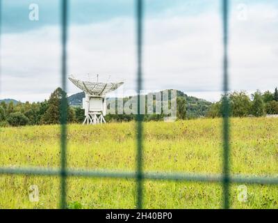 Boîte de communication au micro-ondes derrière la clôture, dans un endroit sûr.Grands récepteurs de paraboles pour la communication par satellite Banque D'Images